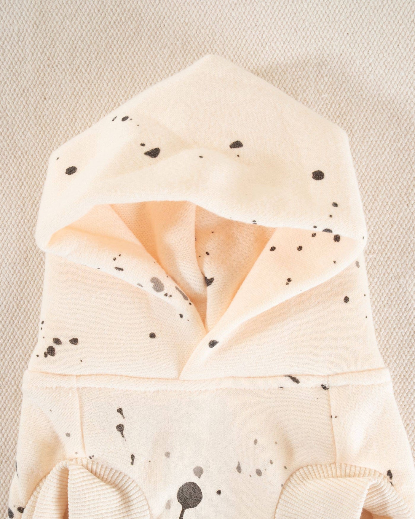 Trendy short sleeve hoodie for small to medium dogs featuring a playful paint splatter print in ivory.