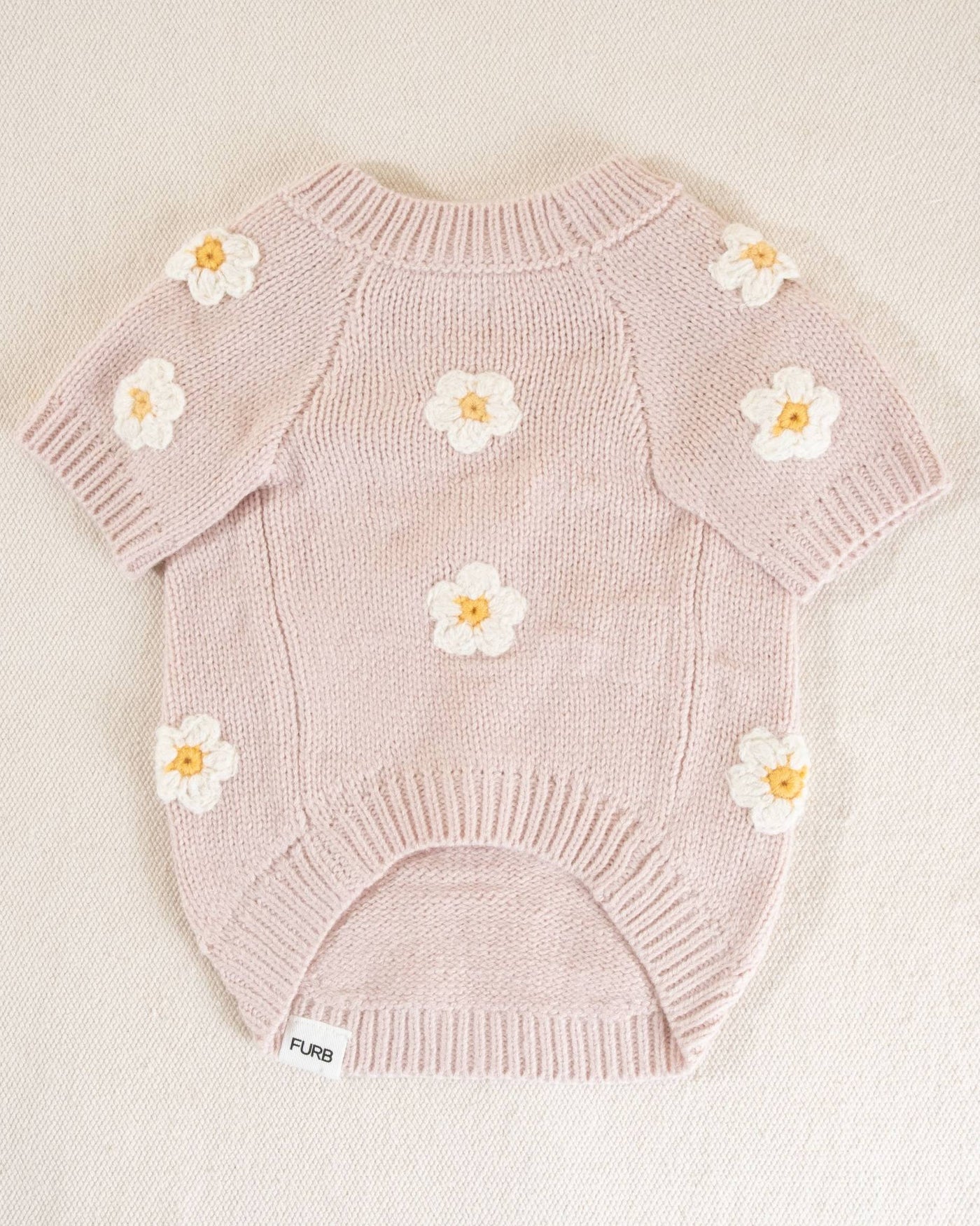 Soft pink dog sweater with a cute daisy pattern, designed for small to medium dogs looking to stay warm in style.